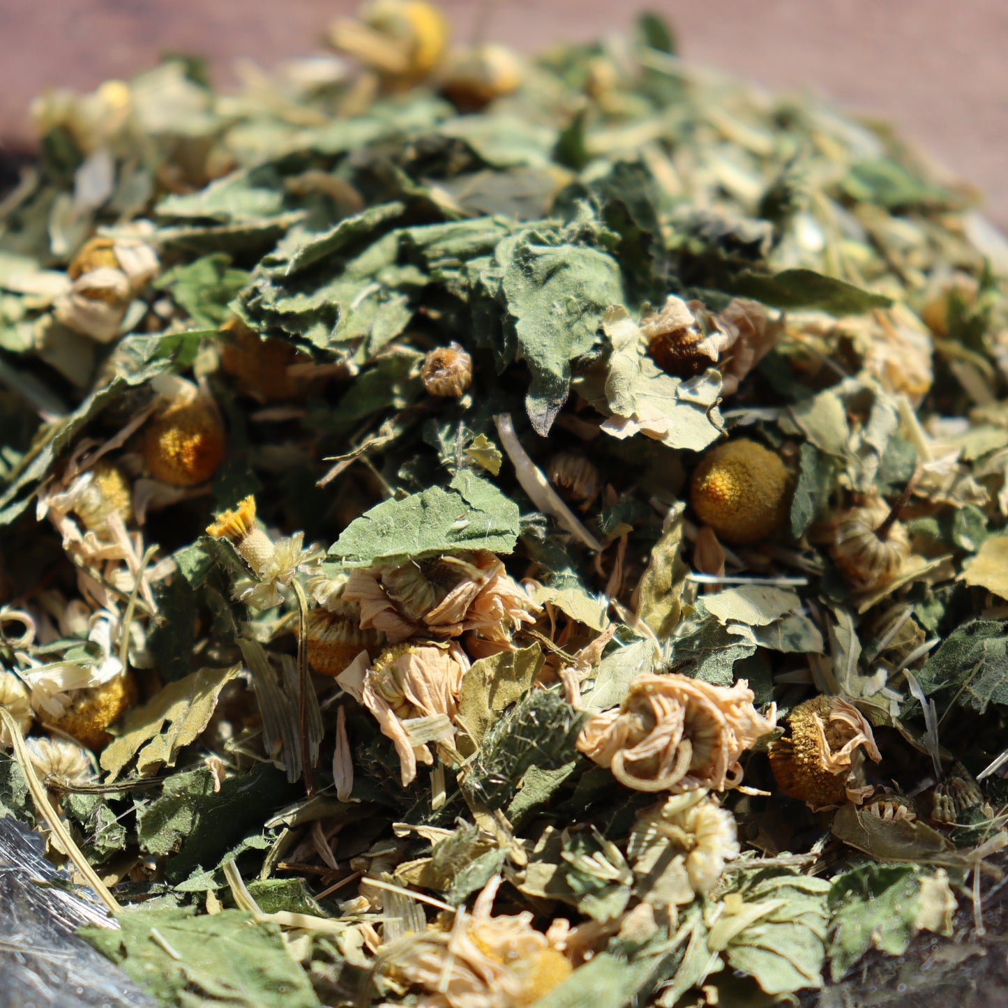 Dried herbs and leaves on a wooden surface