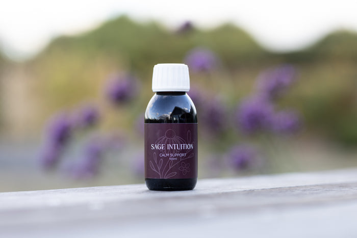 Sage Intuition Calm Support herbal tincture bottle with a purple label and white cap, pictured outdoors.