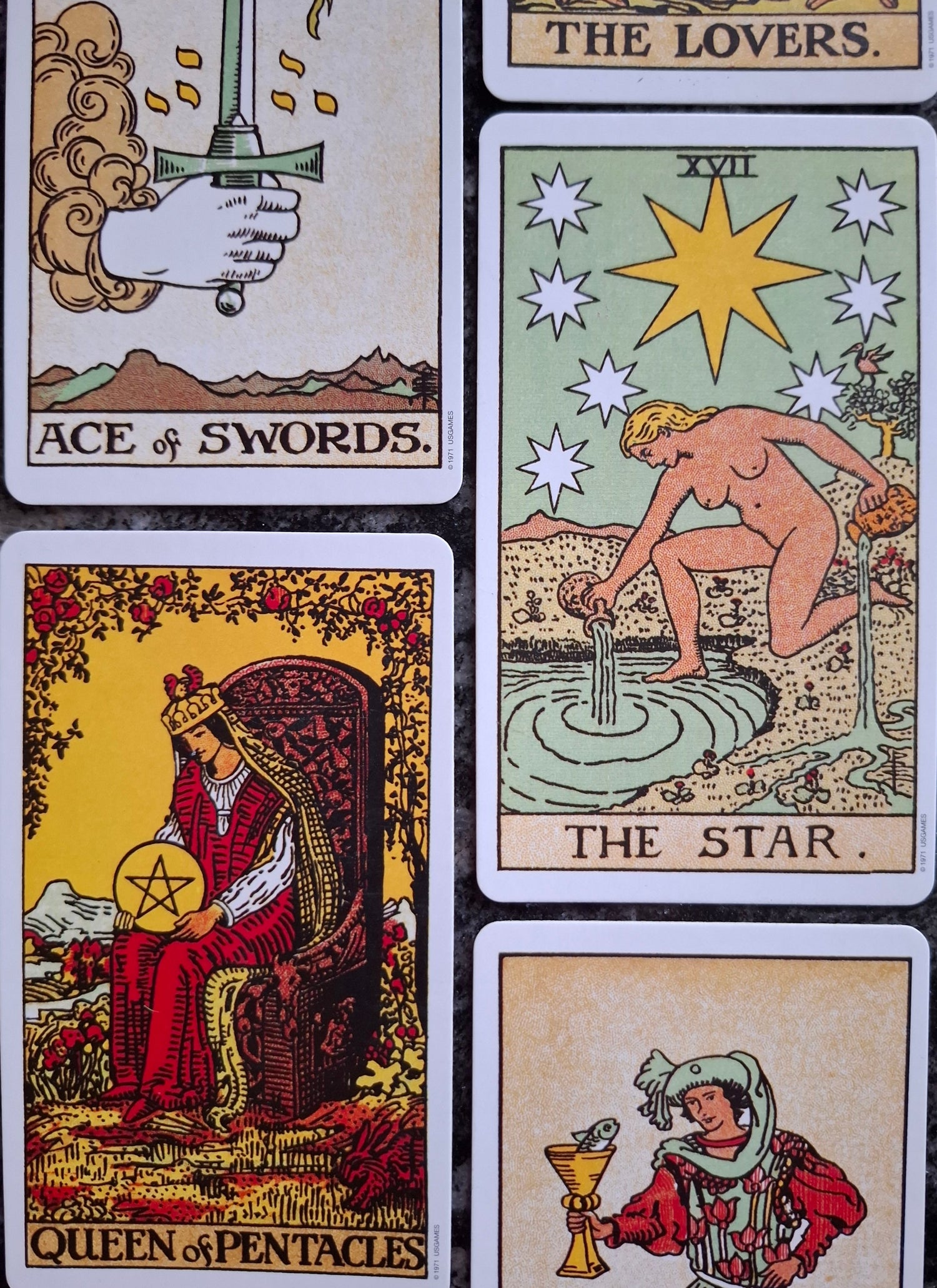 Collection of tarot cards including 'Ace of Swords', 'The Star', and 'Queen of Pentacles' on a textured surface.