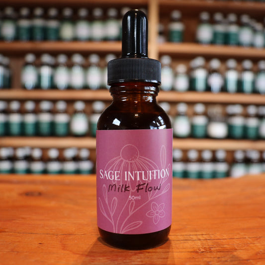 Bottle of Sage Intuition breast feeding milk flow support tincture on a wooden surface with shelves of similar bottles in the background.