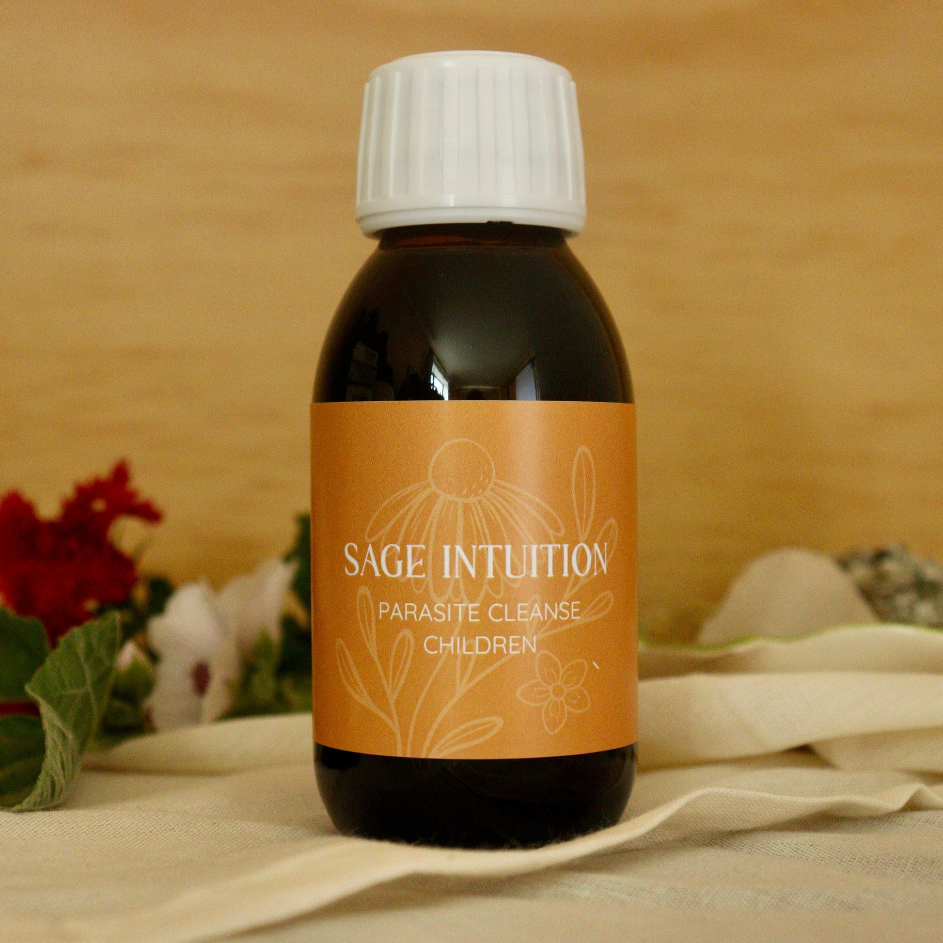 Bottle of Sage Intuition product on a wooden surface with flowers and leaves.