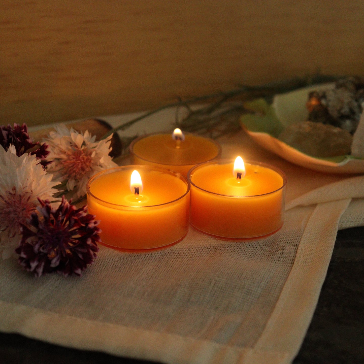Candlelit scene with flowers and a plate on a tablecloth